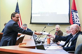Michael B. Heister, Attorney for Eco-Vista, hands out printed copies of his presentation to members of the Pollution Control and Ecology Commission during a discussion of a proposed expansion of a landfill in Tontitown during a Commission Meeting on Friday, April 26, 2024.

(Arkansas Democrat-Gazette/Stephen Swofford)